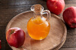 A bottle of apple cider vinegar with red apples in the background