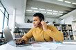© Kateryna - Concentrated hispanic business man wearing headset, having a video call with colleagues. Confident male employee discuss business plan with coworkers, communication concept