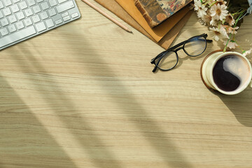 Top view of comfortable workspace with notebook, coffee cup and copy space on wooden table.