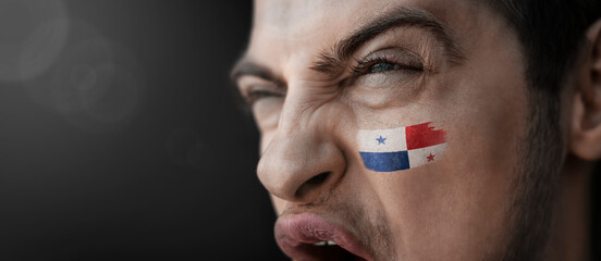 A screaming man with the image of the Panama national flag on his face