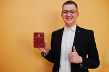 Young Handsome Man Holding Republic Of Colombia Passport Id Over Yellow Background, Happy And Show Thumb Up. Travel To America Countries.