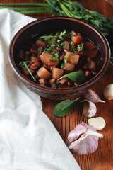 Sticker - Bean soup with herbs in a clay bowl with fresh rye bread and garlic on a slate table on a dark background.