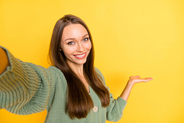 Wall Mural - Photo portrait of woman showing blank space with hand taking selfie isolated on vivid yellow colored background