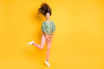 Wall Mural - Full size photo of young pretty beautiful happy joyful funky girl with flying hair isolated on yellow color background