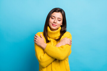 Poster - Close-up portrait of lovely cheery dreamy girl hugging herself enjoying isolated over shine blue color background