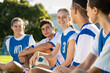 © Rido - Happy smiling young football players sitting in field