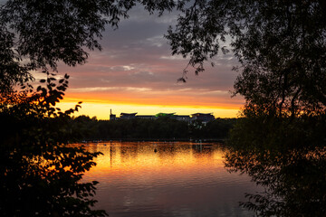 Sunset summer sunrise sky at Kings Mill Reservoir in Mansfield Nottinghamshire with a hospital and reflection of stunning orange skies in the Nottingham water peaceful scenic view dramatic silhouette