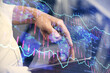 © peshkova - Double exposure of man's hands holding and using a digital device and forex graph drawing. Financial market concept.