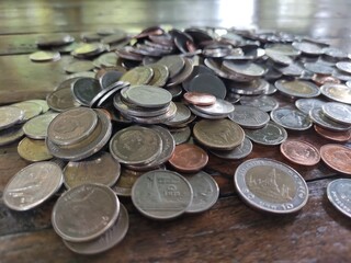 Many kinds of Thai coins on a wooden table