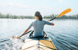 © Alex Photo - Young woman paddling in yellow color kayak on calm lake on sunny summer day, rear view.