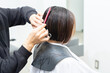 © garage38 - ヘアサロンで髪の毛をカットしてもらう若い女性