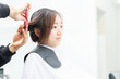 © garage38 - ヘアサロンで髪の毛をカットしてもらう若い女性
