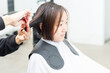 © garage38 - ヘアサロンで髪の毛をカットしてもらう若い女性
