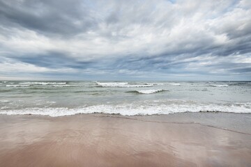 panoramic view of the baltic sea from a sandy shore (sand dunes). dramatic sky with glowing clouds, 