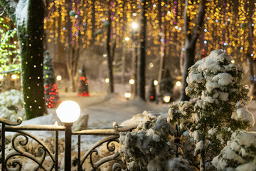 the winter park is decorated with garlands, the beautiful photo zone is covered with snow, the fabulous atmosphere of the night city