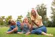 © New Africa - Happy family blowing soap bubbles in park on green grass