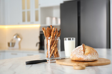 Sticker - Loaf of bread and knife on white table in kitchen. Space for text