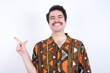 Young caucasian man wearing generic pattern printed shirt against yellow wall pointing up with fingers number eight in Chinese sign language BÄ.