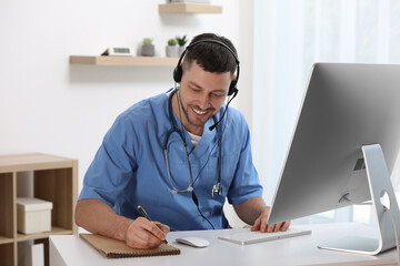 Wall Mural - Doctor with headset consulting patient online at desk in clinic. Health service hotline