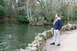 © photointruder - young man standing looking at the water of a lake