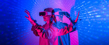 Young Woman Using Glasses Of Virtual Reality On Dark Background. Smartphone Using With VR Headset,virtual Reality,future Technology Concept.Asian Woman Using VR Glasses In Colorful Neon Lights.