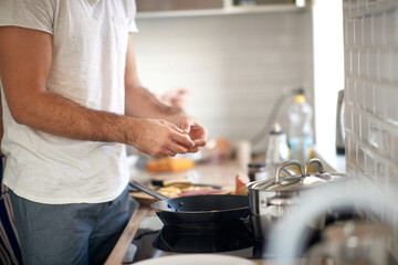 Wall Mural - A young guy making a meal. Kitchen, food, home, cooking