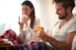 © luckybusiness - A young couple enjoying a breakfast in the bed. Love, relationship, together