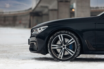 Canvas Print - Front-wheel of a modern luxury car at the snow parking