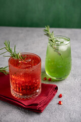 Two colorful summer cocktails in glasses on  grey table. Assortment of fresh  summer drinks. Red sangria cocktails, margarita cocktail, tropical mule.