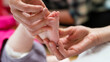 © Cavan Images - a physiotherapist manually treats an infant's foot