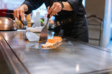 Hand of Chef cooking salmon steak