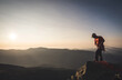 © Cavan Images - Man belaying with climbng ropes at sunrise in mountains