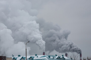 Wall Mural - industrial chimneys with heavy smoke causing air pollution on the gray smoky sky background