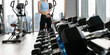 © kowitstockphoto - woman wearing sports clothes weighing dumbbells in hands during workout in gym