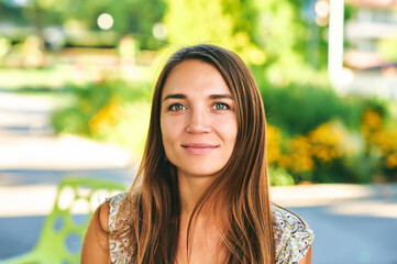 Outdoor close up portrait of beautiful woman resting in summer park