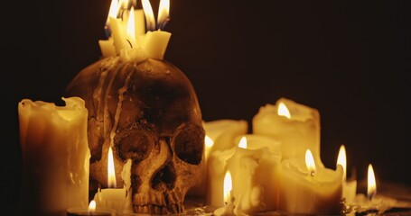 Wall Mural - Candles and human skull in darkness closeup footage