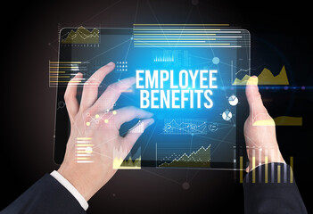 Close-up of hands holding tablet with EMPLOYEE BENEFITS inscription, modern business concept