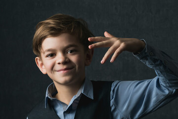 A little boy with brown eyes in a shirt poses for the camera.Portrait