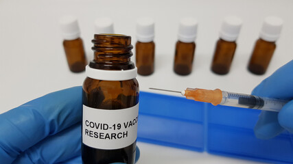 Wall Mural - Laboratory assistant holding a vial of Covid-19 vaccine and a syringe