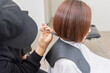 © garage38 - ヘアサロンで髪の毛をカットする美容師の手元