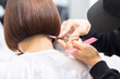 © garage38 - ヘアサロンで髪の毛をカットする美容師の手元