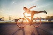 Athletic girl performing acrobatic riding on electric bike