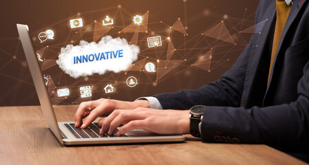 businessman working on laptop with innovative inscription, modern technology concept