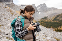 Teenage Girl Using Digital SLR Camera On Hike In Craggy Mountains