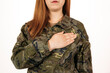 © miguel - Woman in military camouflage standinwith her hand on her heart