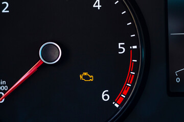 Natural light. the dashboard of the car. The engine error indicator lights up on it. Close-up.