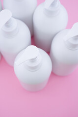 Poster - Vertical shot of white plastic bottles on a pink surface