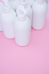 Poster - Vertical shot of white plastic bottles on a pink surface