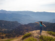 © Alexander - tourist stands on top of a mountain with her arms outstretched, Hiking in the mountains.