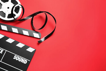 Canvas Print - Clapboard and reel on red background, flat lay with space for text. Video production equipment